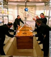 The triple-coffin is lowered into the tomb